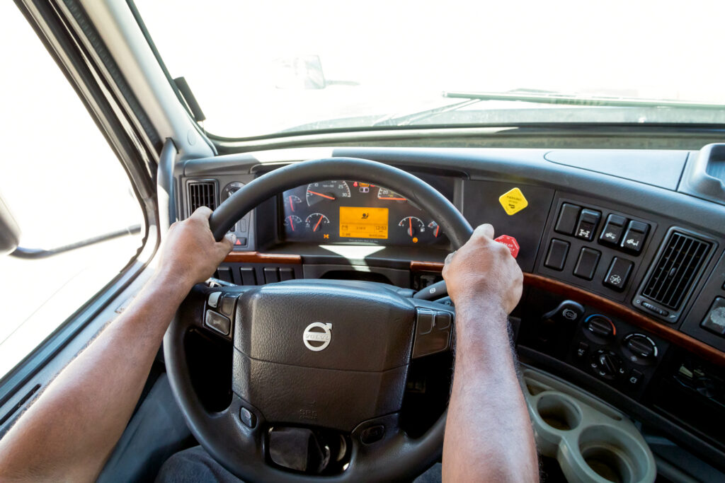 Driver practicing behind the wheel of a Volvo truck during training.