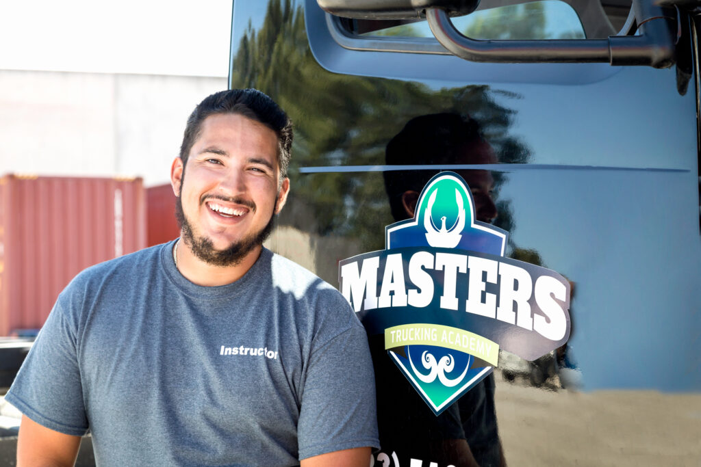 Smiling truck driver standing in front of a Masters Trucking vehicle.